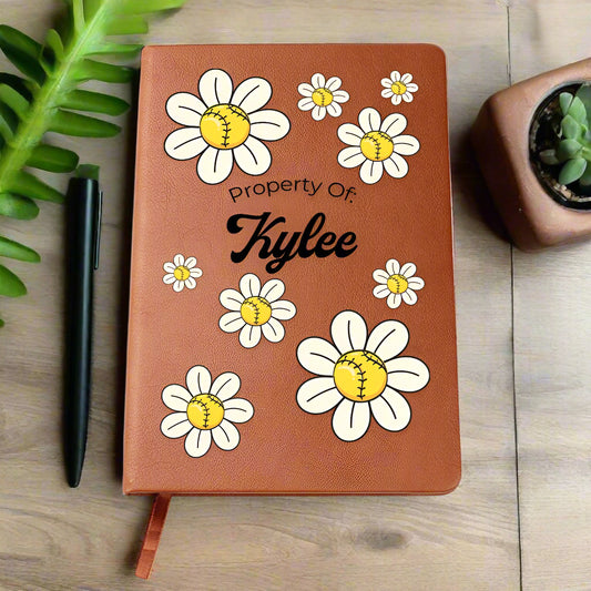 Brown notebook with daisy flower designs and 'Property Of: Kylee' text on a white background